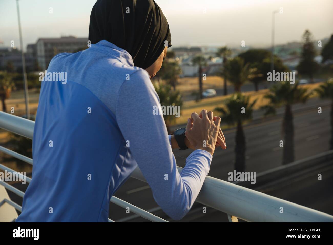 Femme en hijab utilisant une montre intelligente sur une passerelle Banque D'Images