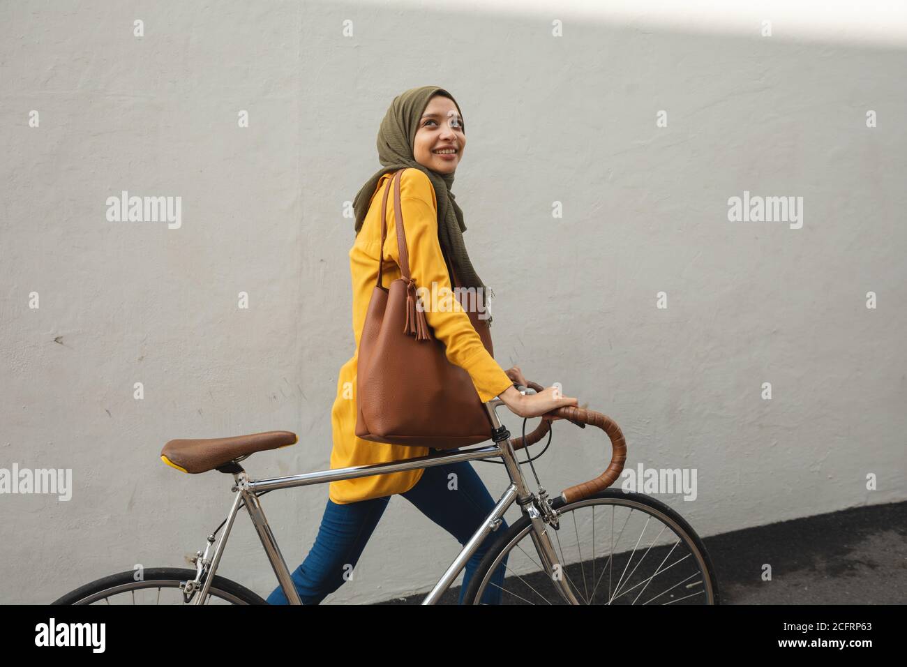 Femme en hijab marchant avec un vélo Banque D'Images Femme en hijab marchant avec un vélo Banque D'Images