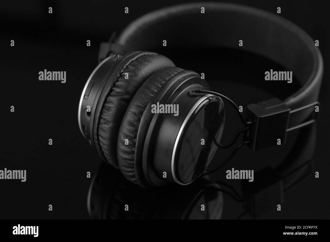 casque sans fil noir sur fond noir avec des reflets, de la musique et de la technologie Banque D'Images