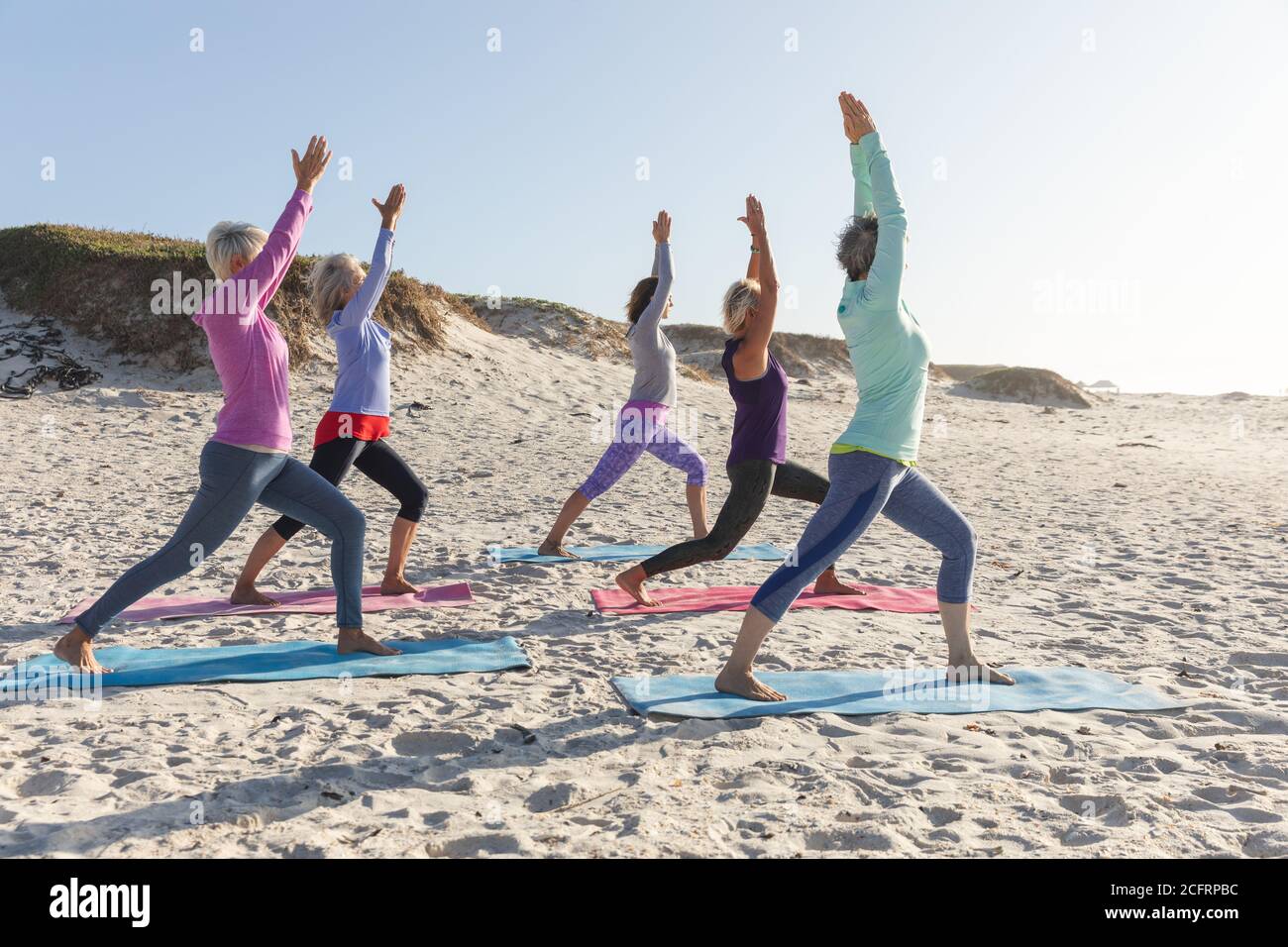 Groupe de femmes pratiquant le yoga sur la plage Banque D'Images Groupe de femmes pratiquant le yoga sur la plage Banque D'Images