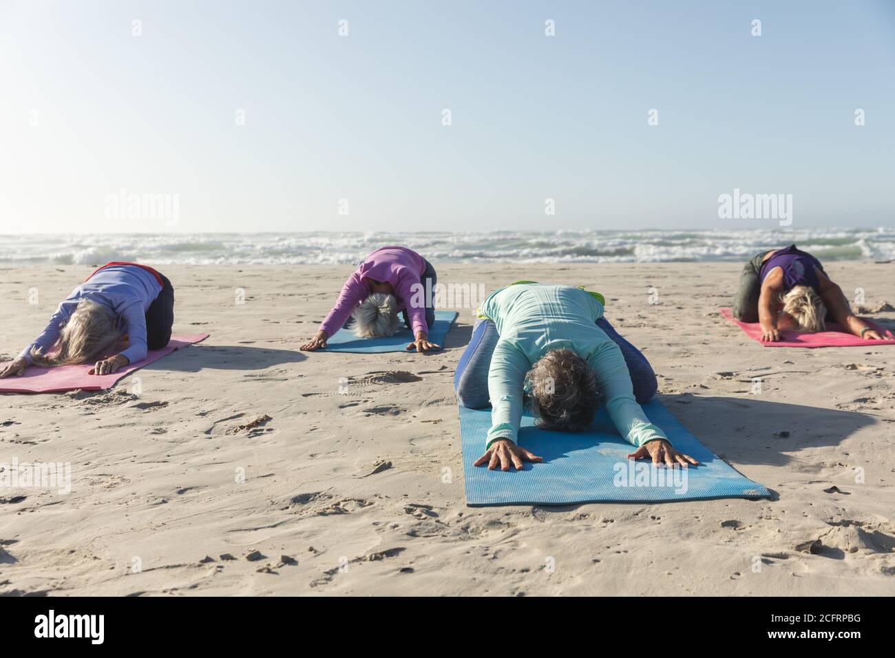 Groupe de femmes pratiquant le yoga sur la plage Banque D'Images Groupe de femmes pratiquant le yoga sur la plage Banque D'Images