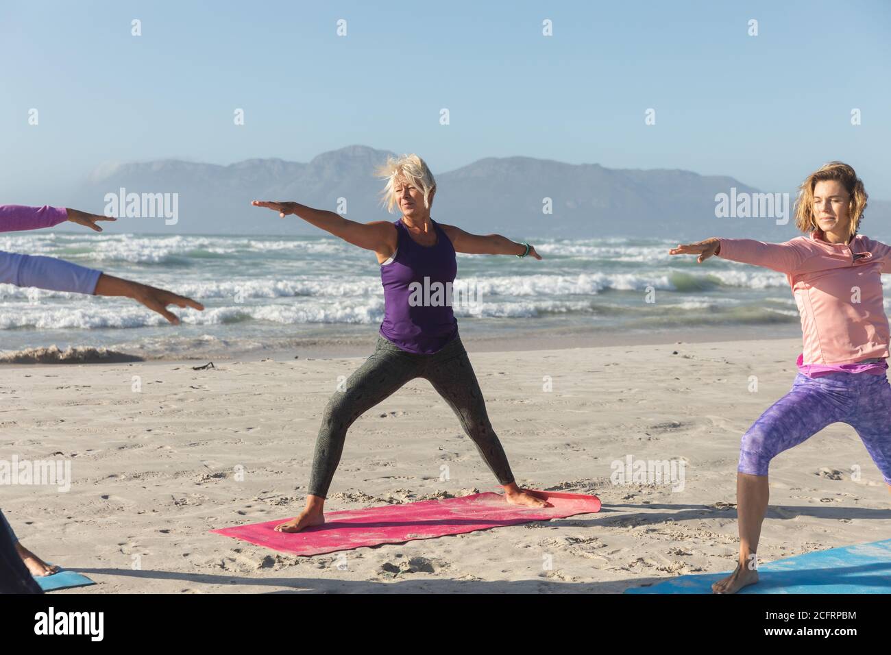 Groupe de femmes pratiquant le yoga sur la plage Banque D'Images Groupe de femmes pratiquant le yoga sur la plage Banque D'Images