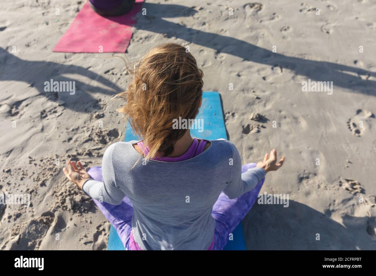 Vue de dessus de la femme pratiquant le yoga sur la plage Banque D'Images Vue de dessus de la femme pratiquant le yoga sur la plage Banque D'Images