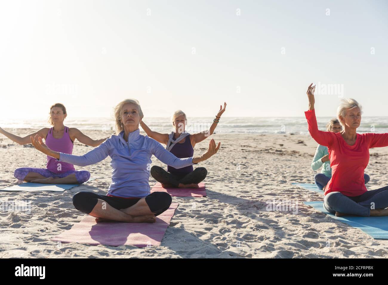Groupe de femmes pratiquant le yoga sur la plage Banque D'Images Groupe de femmes pratiquant le yoga sur la plage Banque D'Images