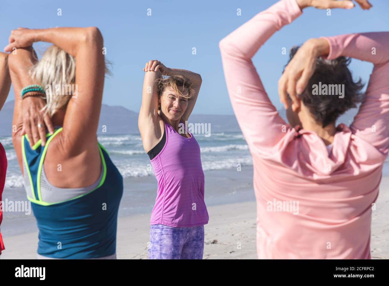 Groupe de femmes effectuant des exercices d'étirement à la plage Banque D'Images Groupe de femmes effectuant des exercices d'étirement à la plage Banque D'Images