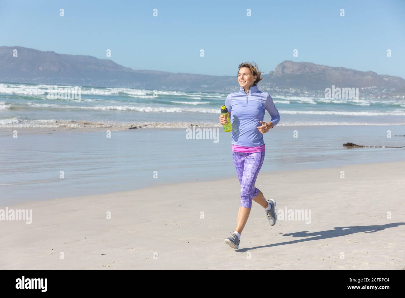 Femme avec une bouteille d'eau sur la plage Banque D'Images Femme avec une bouteille d'eau sur la plage Banque D'Images