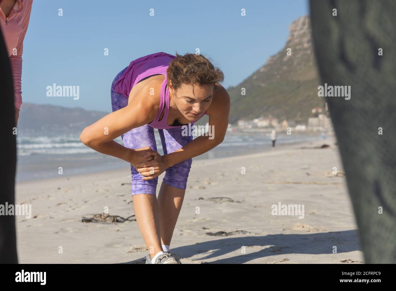 Femme effectuant des exercices d'étirement à la plage Banque D'Images Femme effectuant des exercices d'étirement à la plage Banque D'Images