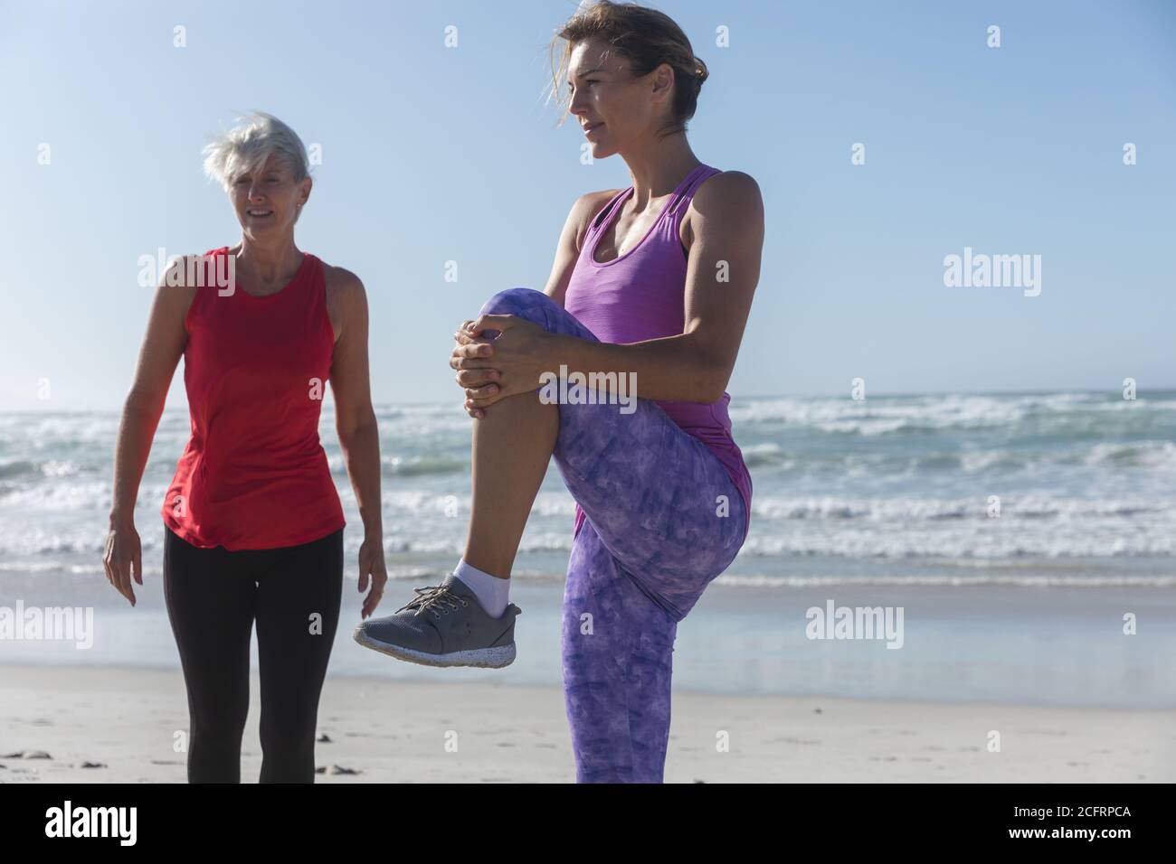 Femme effectuant des exercices d'étirement à la plage Banque D'Images Femme effectuant des exercices d'étirement à la plage Banque D'Images