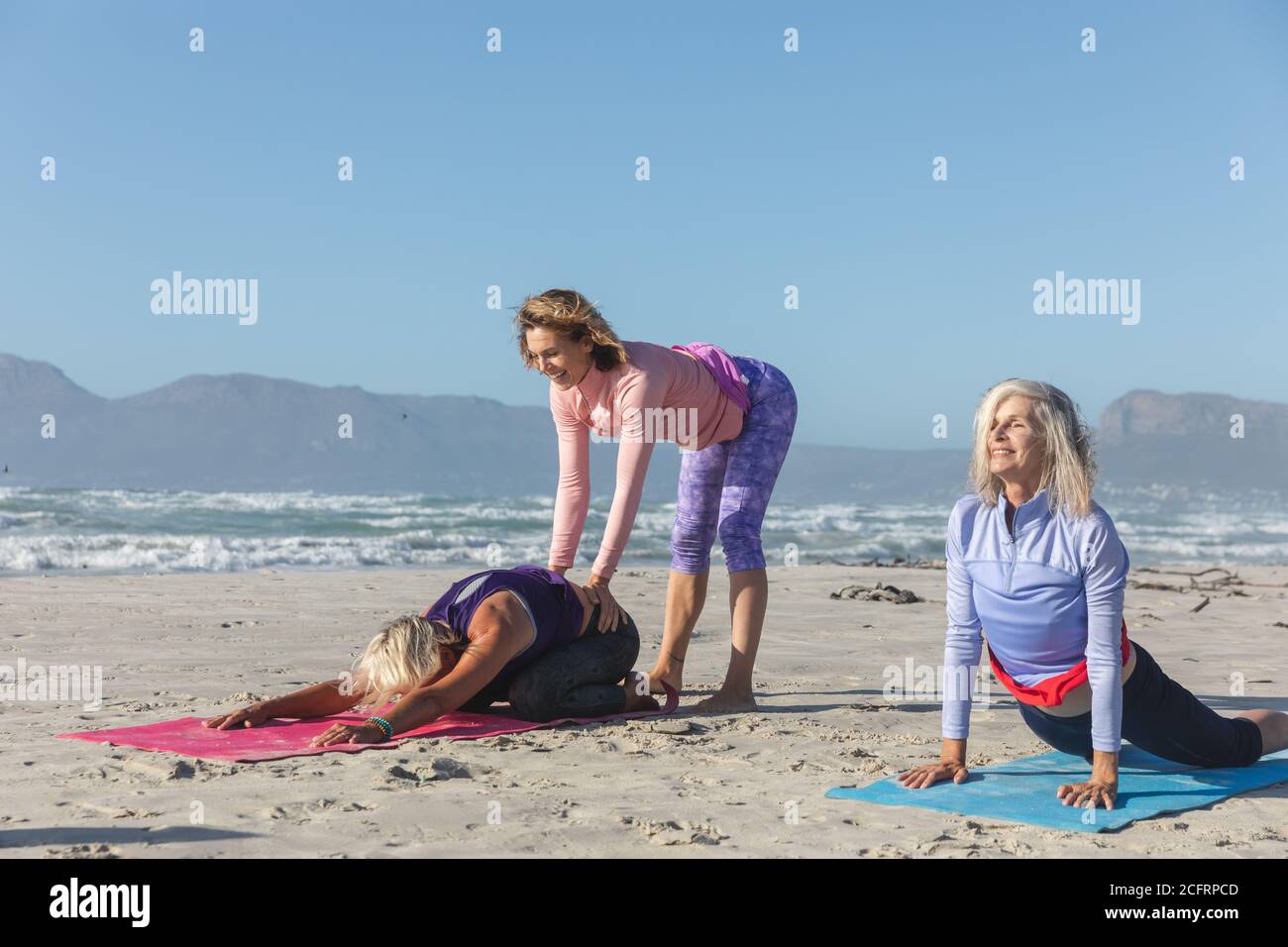 Professeur de yoga enseignant le yoga à un groupe de femmes sur le plage Banque D'Images Professeur de yoga enseignant le yoga à un groupe de femmes sur le plage Banque D'Images