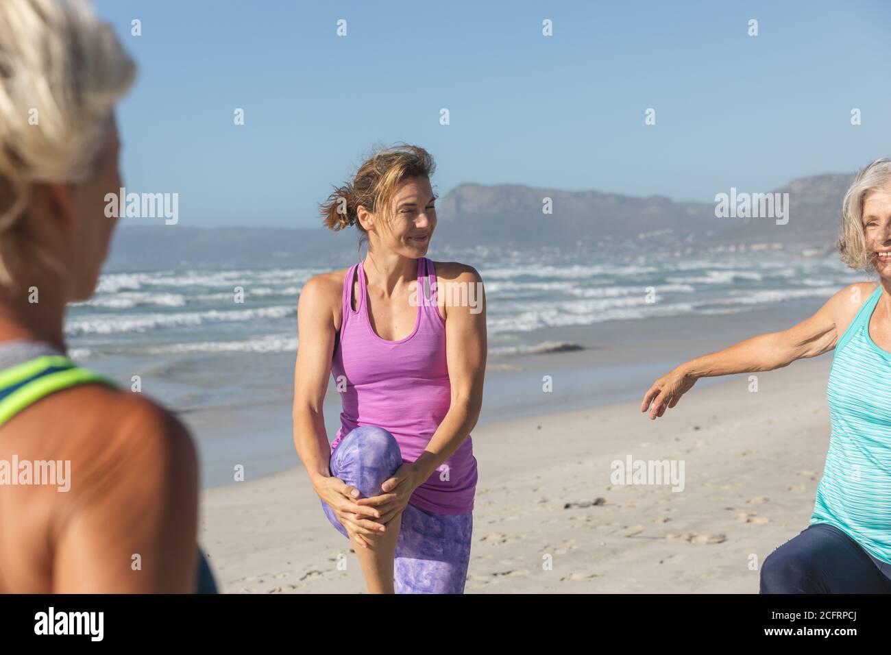 Femme effectuant des exercices d'étirement à la plage Banque D'Images Femme effectuant des exercices d'étirement à la plage Banque D'Images