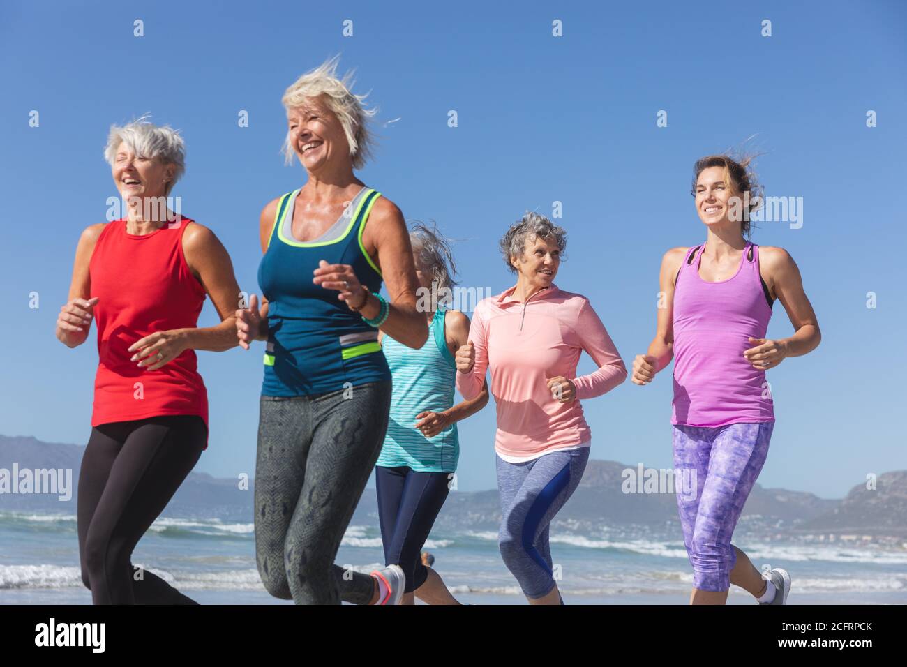 Groupe de femmes courant sur la plage Banque D'Images Groupe de femmes courant sur la plage Banque D'Images