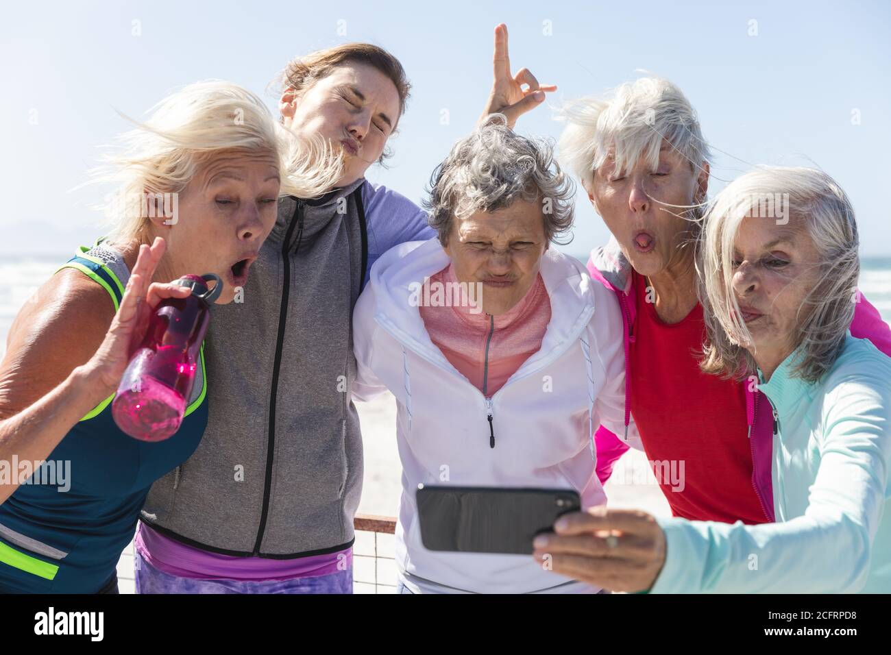 Groupe de femmes faisant des visages drôles tout en prenant un selfie sur la plage Banque D'Images Groupe de femmes faisant des visages drôles tout en prenant un selfie sur la plage Banque D'Images