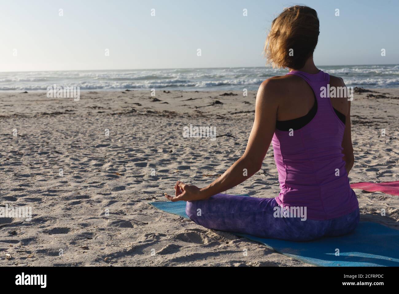 Vue arrière d'une femme pratiquant le yoga sur la plage Banque D'Images Vue arrière d'une femme pratiquant le yoga sur la plage Banque D'Images