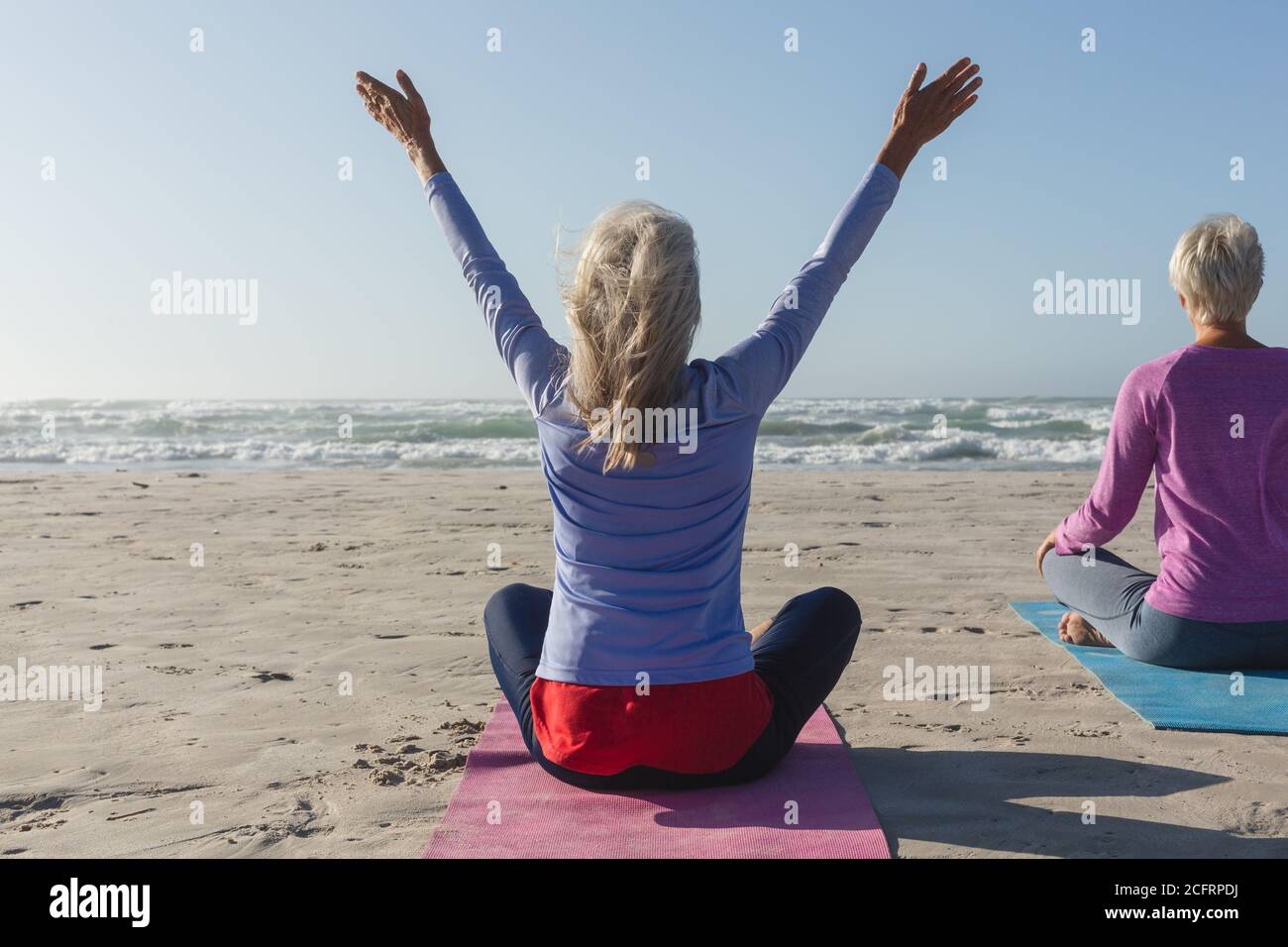 Vue arrière d'une femme pratiquant le yoga sur la plage Banque D'Images Vue arrière d'une femme pratiquant le yoga sur la plage Banque D'Images