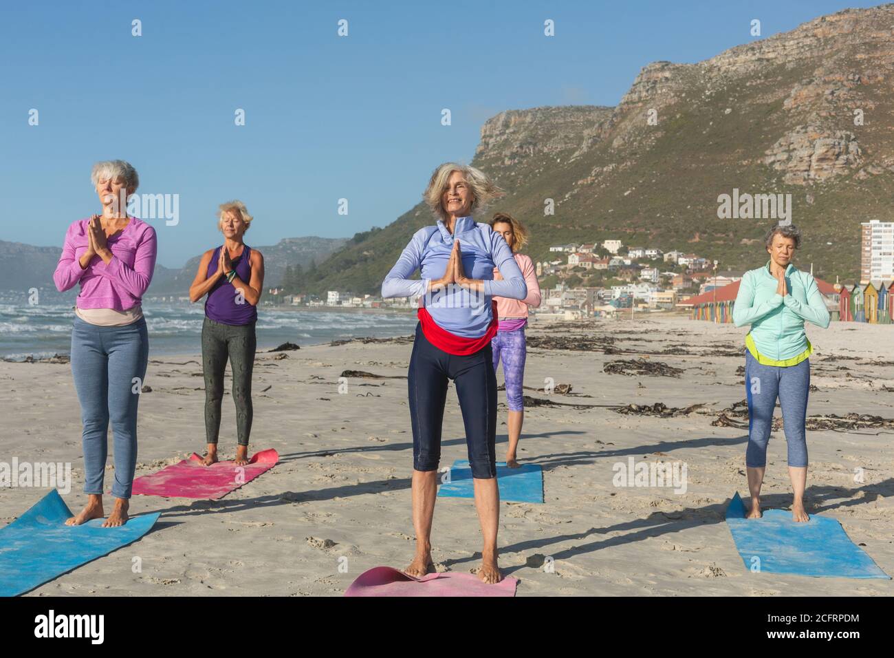 Groupe de femmes pratiquant le yoga sur la plage Banque D'Images Groupe de femmes pratiquant le yoga sur la plage Banque D'Images
