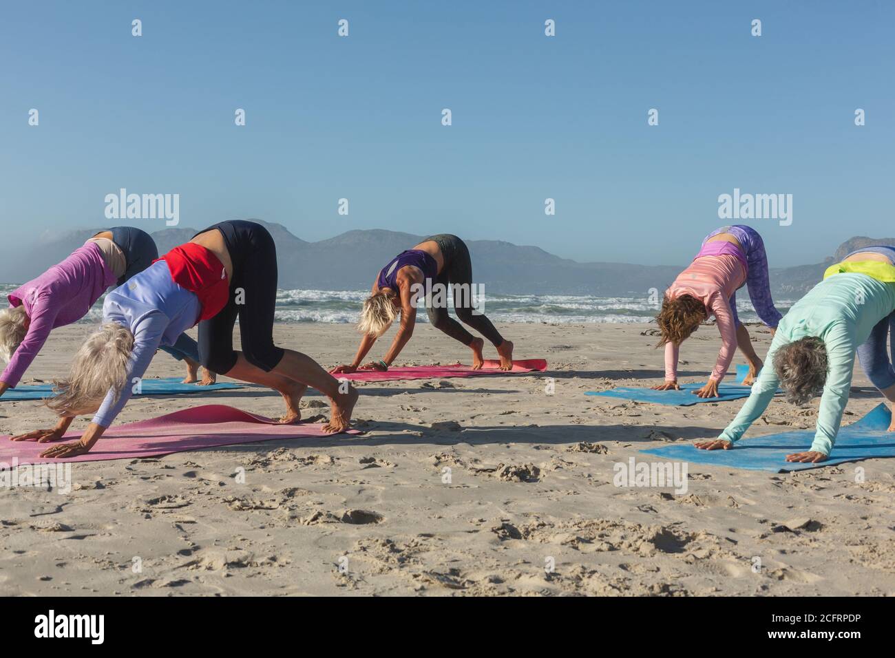 Groupe de femmes pratiquant le yoga sur la plage Banque D'Images Groupe de femmes pratiquant le yoga sur la plage Banque D'Images
