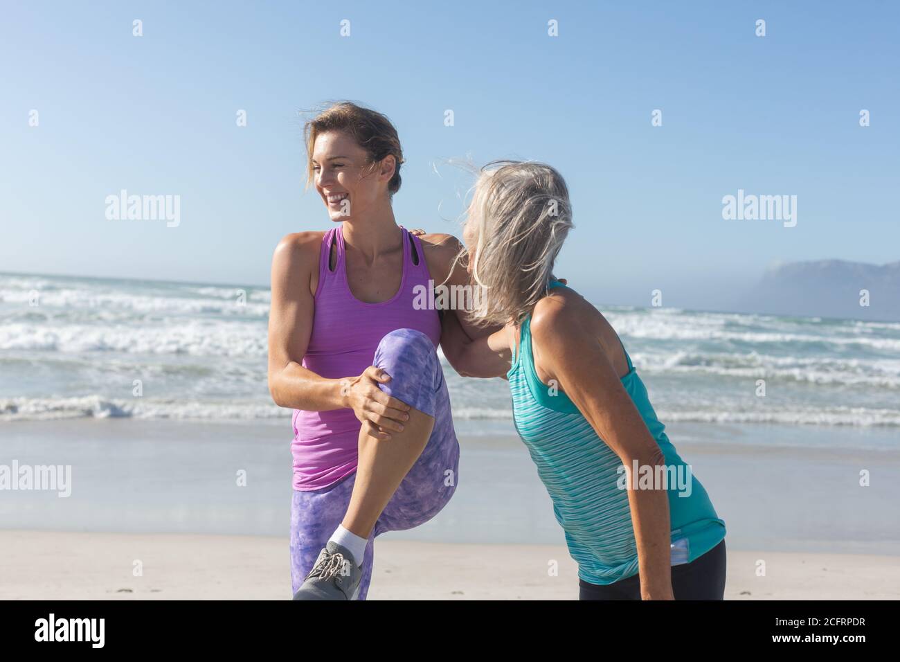 Femme effectuant des exercices d'étirement à la plage Banque D'Images Femme effectuant des exercices d'étirement à la plage Banque D'Images