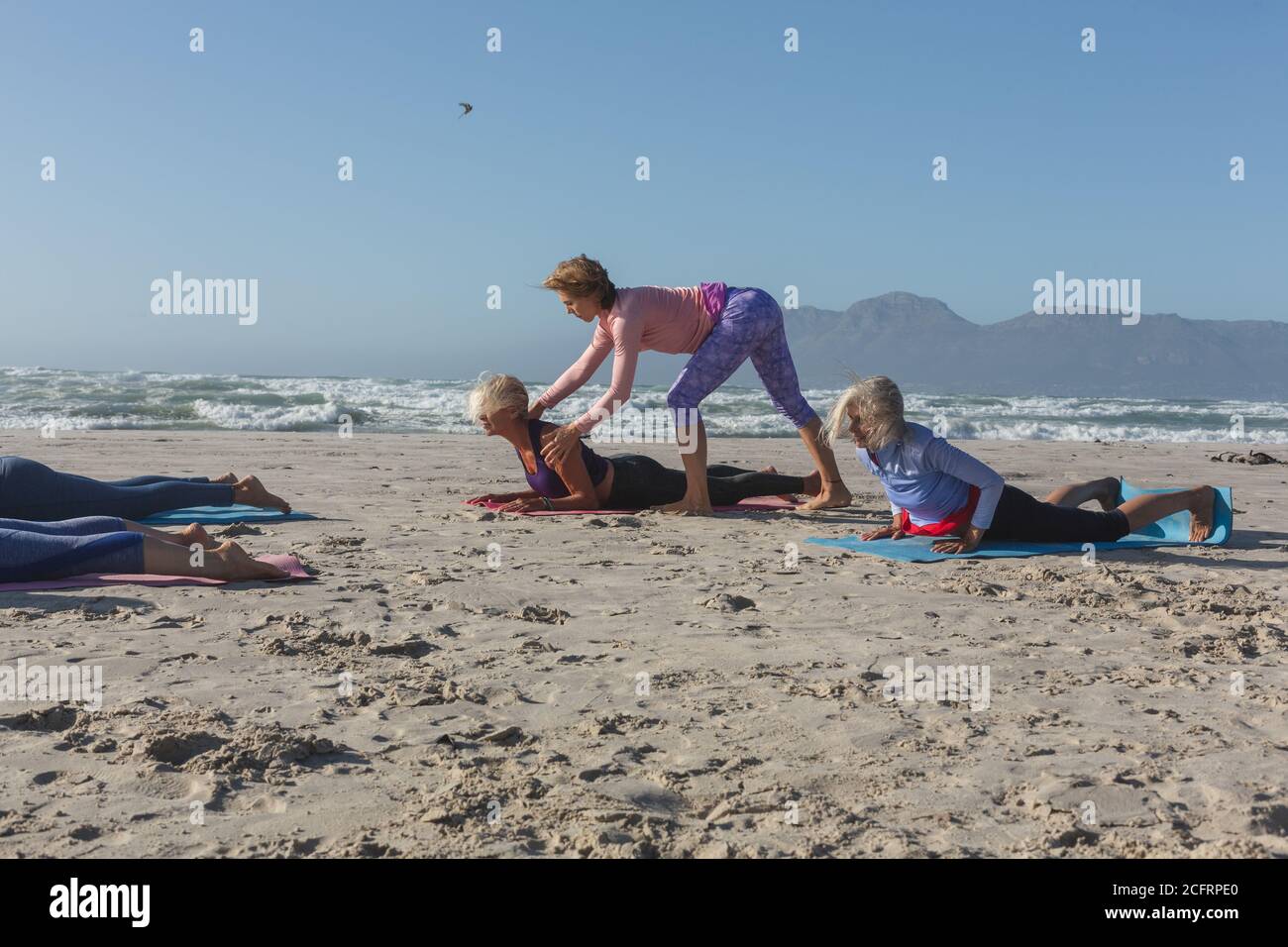 Professeur de yoga enseignant le yoga à la femme sur la plage Banque D'Images Professeur de yoga enseignant le yoga à la femme sur la plage Banque D'Images