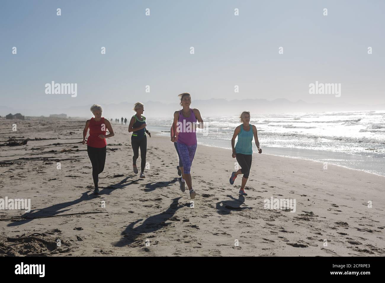 Groupe de femmes courant sur la plage Banque D'Images Groupe de femmes courant sur la plage Banque D'Images