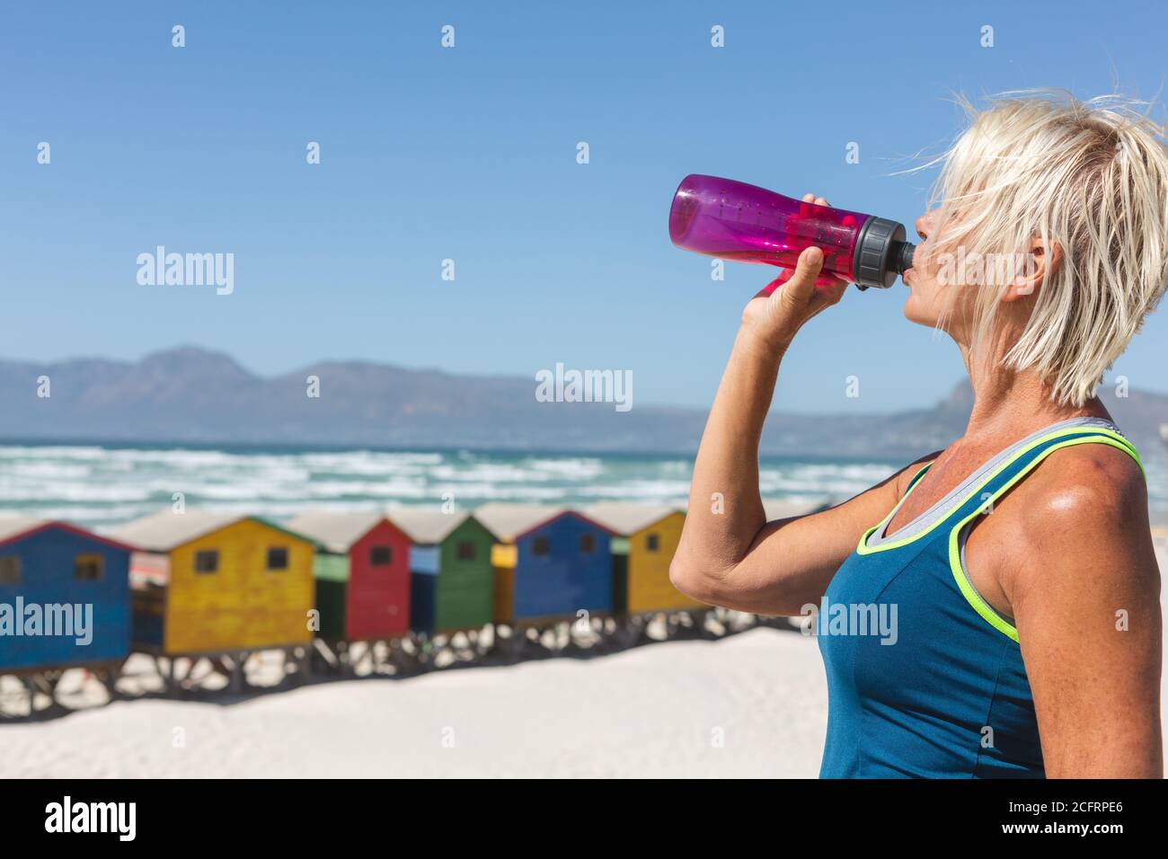 Femme âgée qui boit de l'eau à la plage Banque D'Images Femme âgée qui boit de l'eau à la plage Banque D'Images
