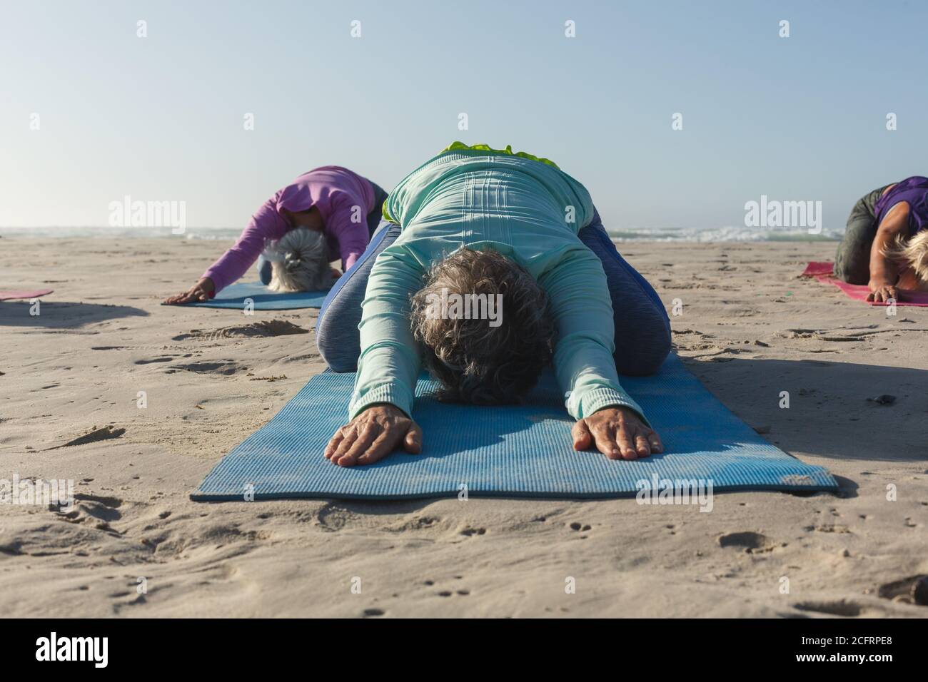 Groupe de femmes pratiquant le yoga sur la plage Banque D'Images Groupe de femmes pratiquant le yoga sur la plage Banque D'Images
