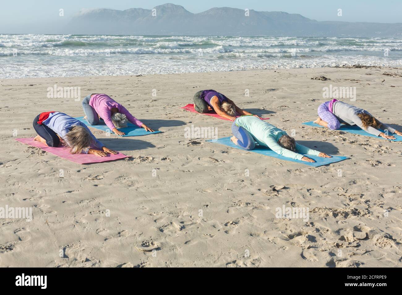 Groupe de femmes pratiquant le yoga sur la plage Banque D'Images Groupe de femmes pratiquant le yoga sur la plage Banque D'Images