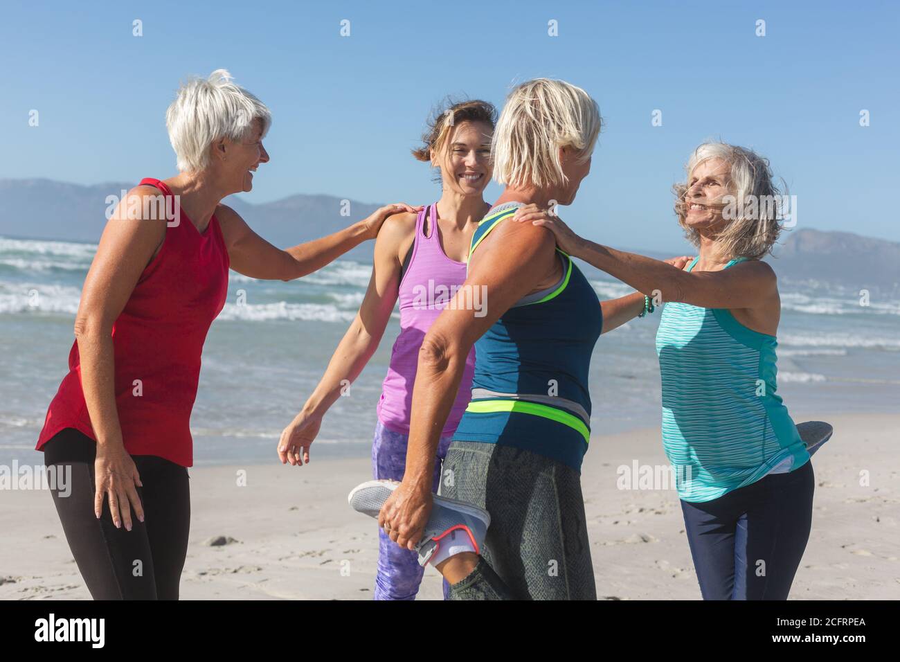 Groupe de femmes effectuant des exercices d'étirement à la plage Banque D'Images Groupe de femmes effectuant des exercices d'étirement à la plage Banque D'Images