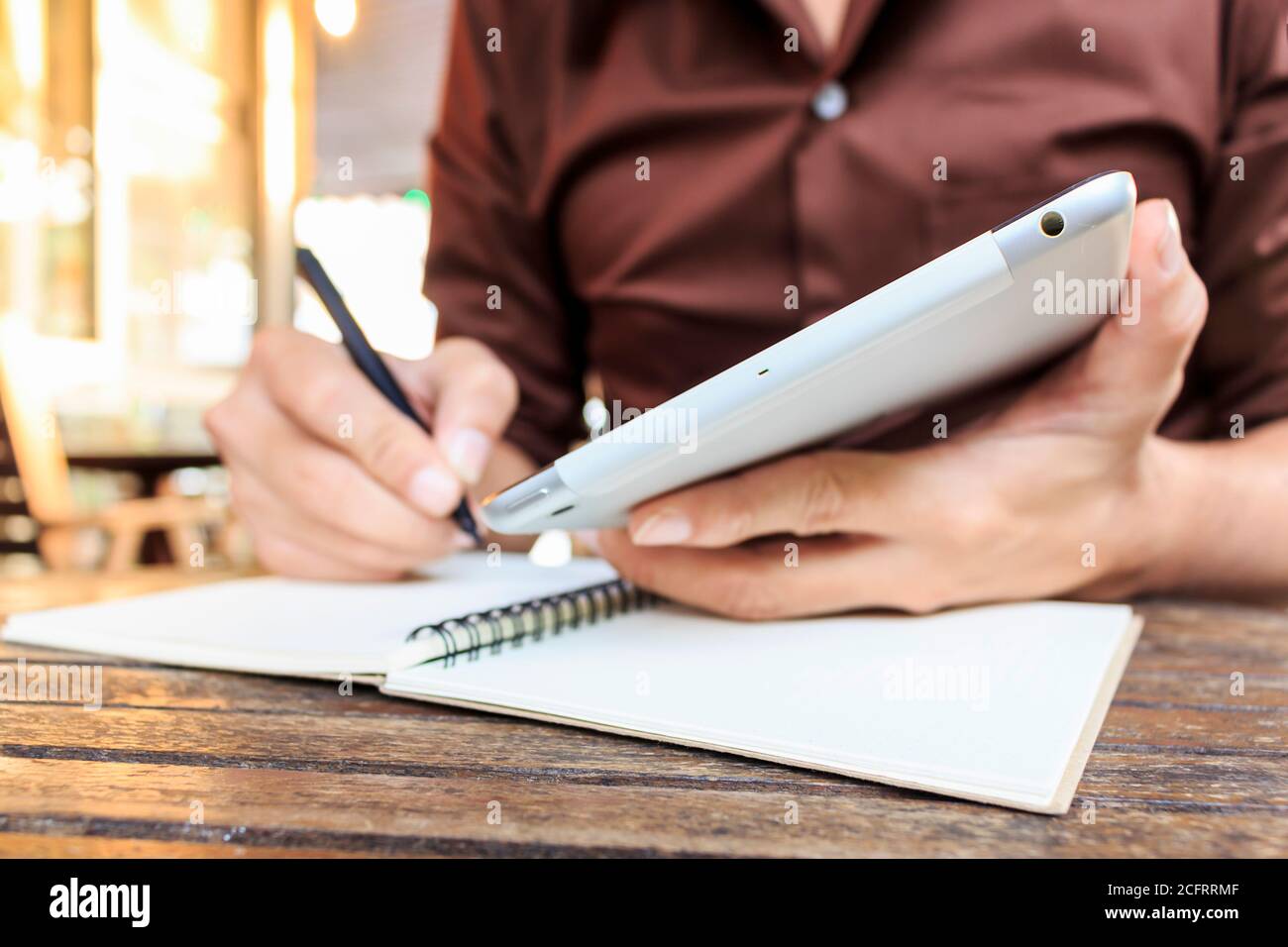 homme d'affaires écrivant des notes de l'ipad mini au café-restaurant. attention sélective, sur la lumière Banque D'Images