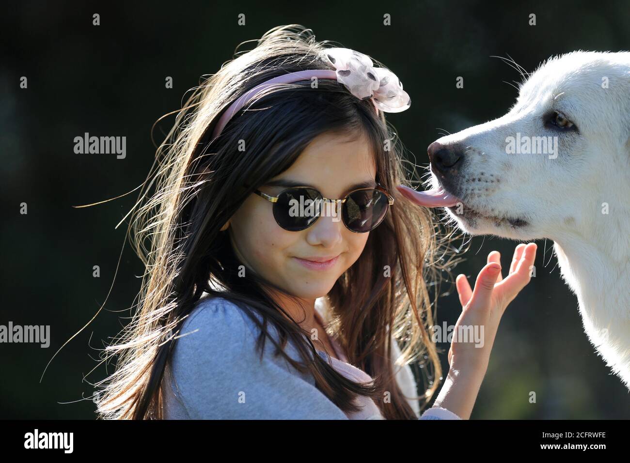 jeune fille avec son chien de chiot blanc et sympathique embrassant elle Banque D'Images