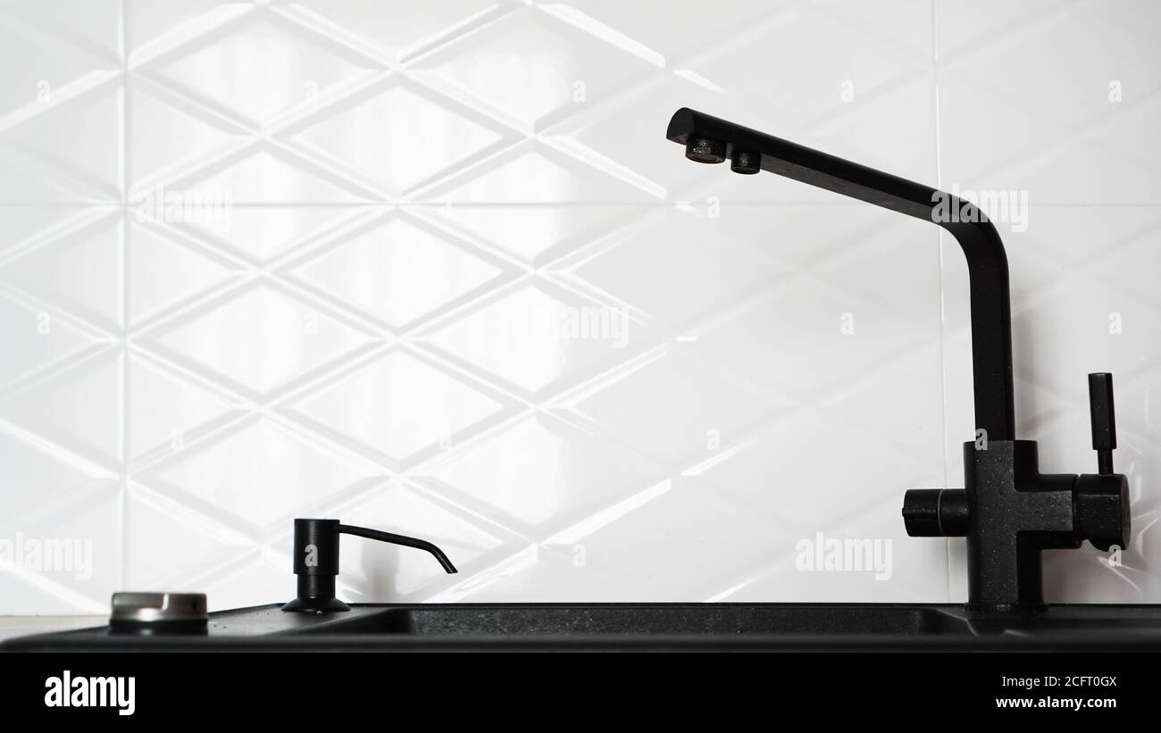 Évier de cuisine noir dans le design intérieur blanc moderne de la cuisine Banque D'Images