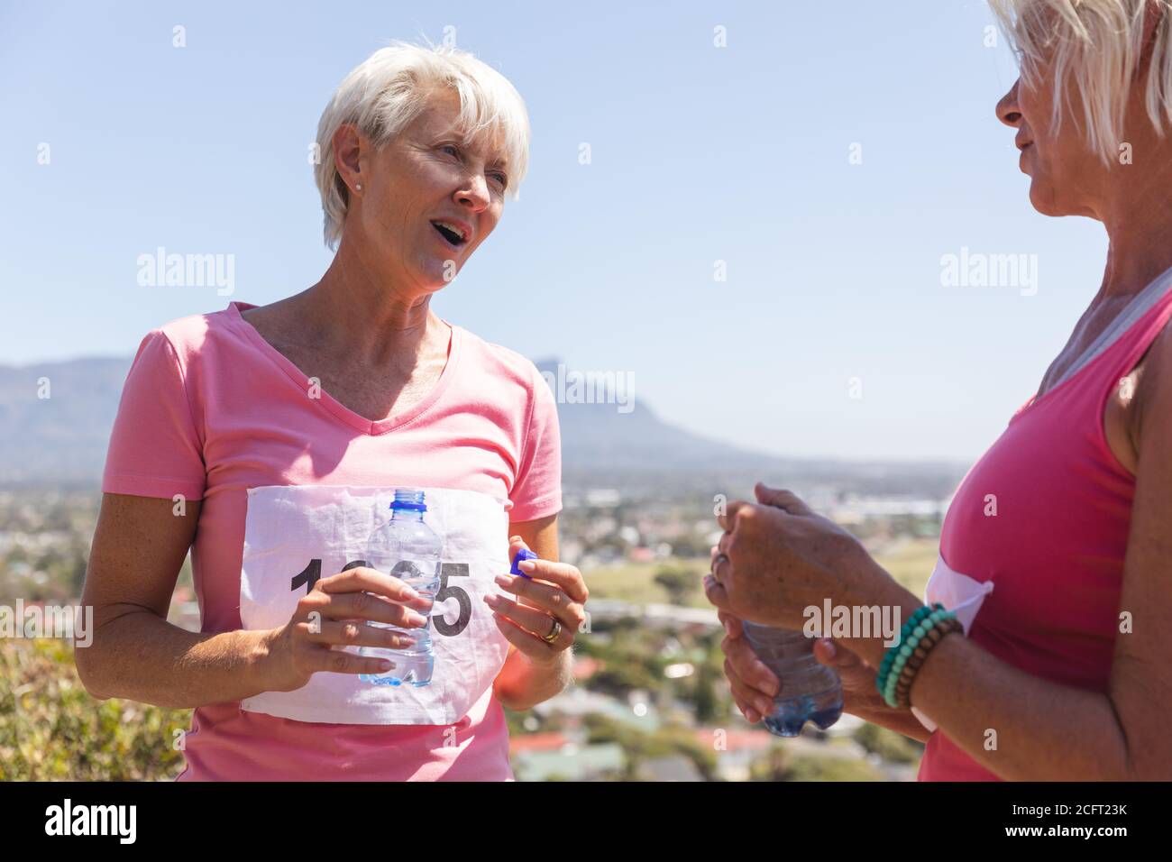 Deux femmes âgées avec une bouteille d'eau qui parlent l'une à l'autre Banque D'Images Deux femmes âgées avec une bouteille d'eau qui parlent l'une à l'autre Banque D'Images