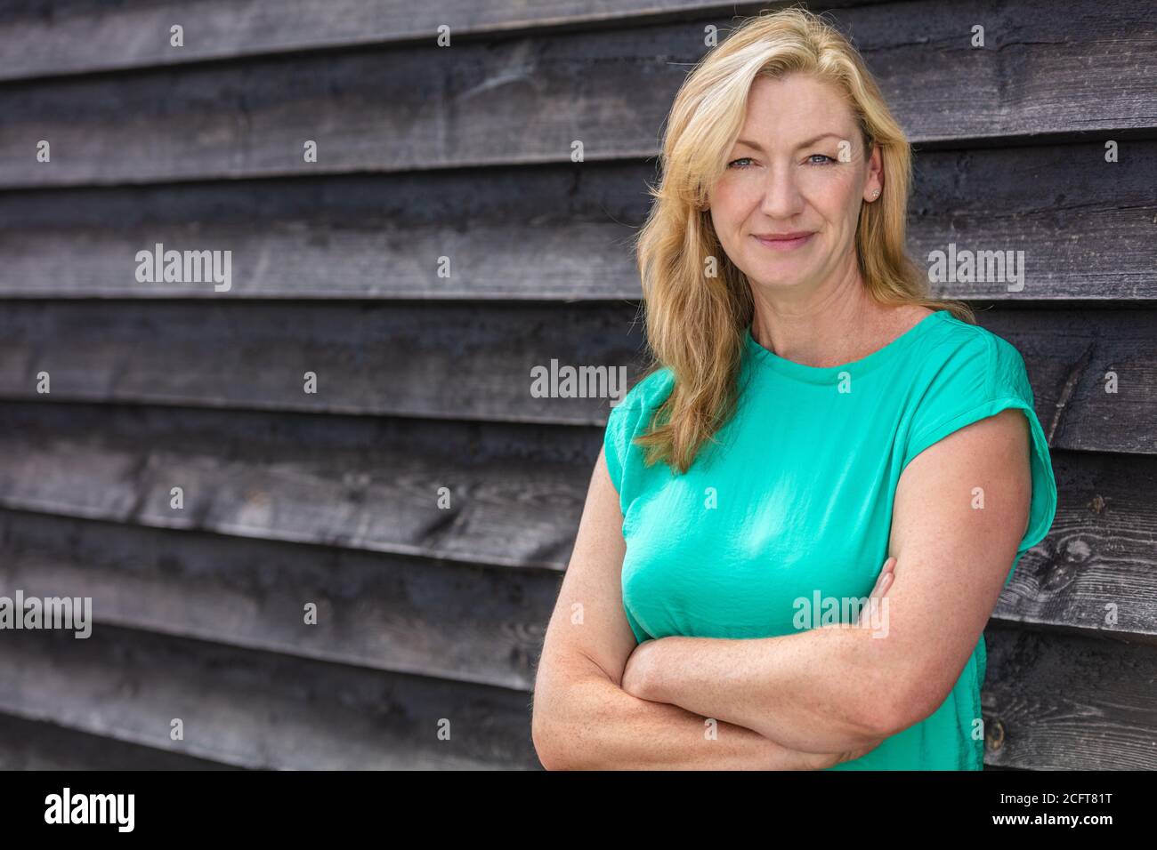 Portrait extérieur d'une jolie femme blonde d'âge moyen souriante Banque D'Images