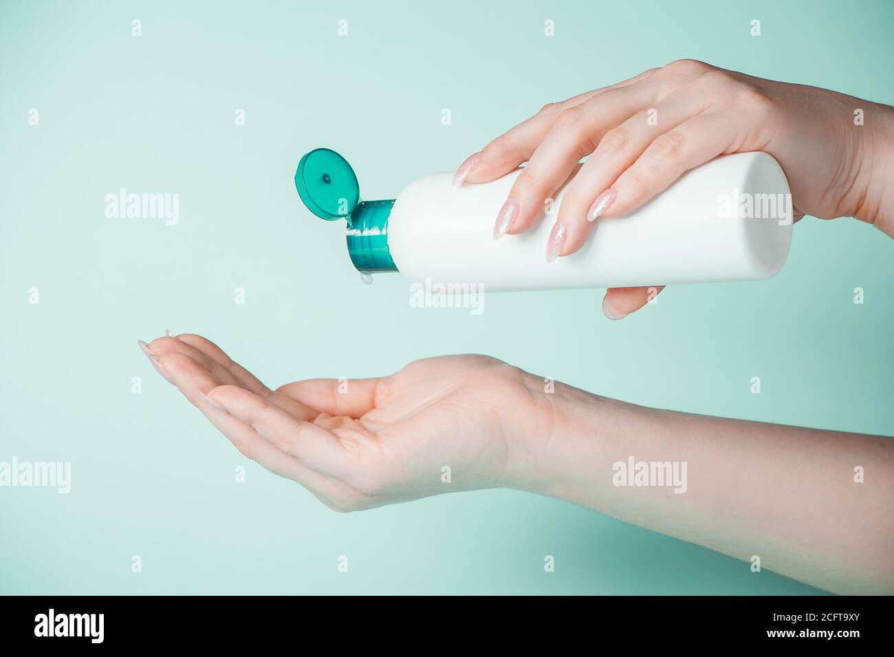Une jeune femme utilise du gel antibactérien pour désinfecter ses mains. Le concept d'hygiène et de prévention du coronavirus. Banque D'Images