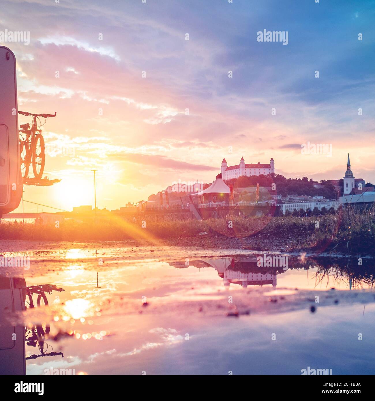 Vue sur le château de Bratislava pendant l'heure d'or avec beau coucher de soleil sur le Danube et le ricochet dans la piscine d'eau du paysage, Slovaquie Banque D'Images