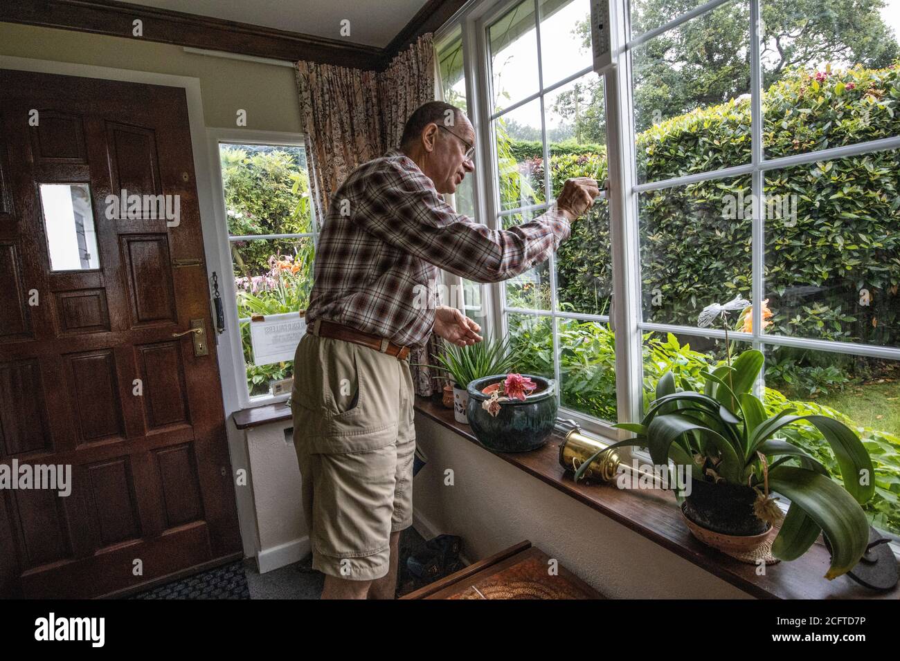 Les couples âgés se sont assis dans leur porche social distancer à la maison pendant le confinement en cas de pandémie du coronavirus, au pays de Galles, au Royaume-Uni Banque D'Images