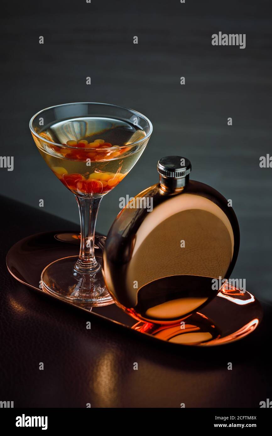 Un Martini moderne servi dans un verre de Martini avec un flacon en cuivre Banque D'Images