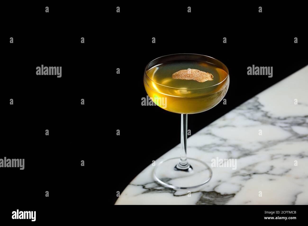 Une petite boisson est servie dans un verre à cocktail avec un blanc truffe Banque D'Images