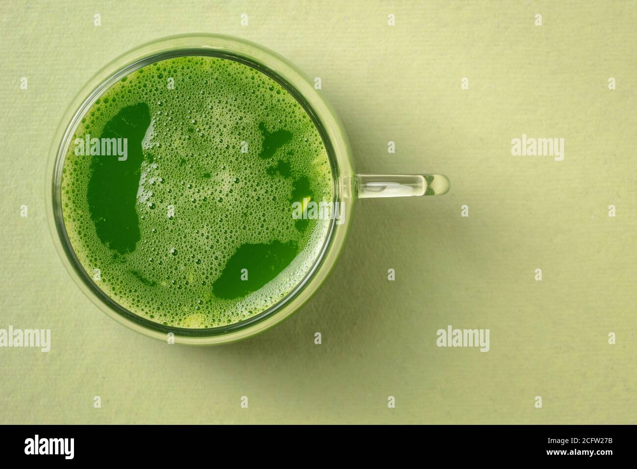 une tasse de verre de jus de concombre frais fait maison sur fond de papier avec un espace de copie, concept de saine alimentation Banque D'Images