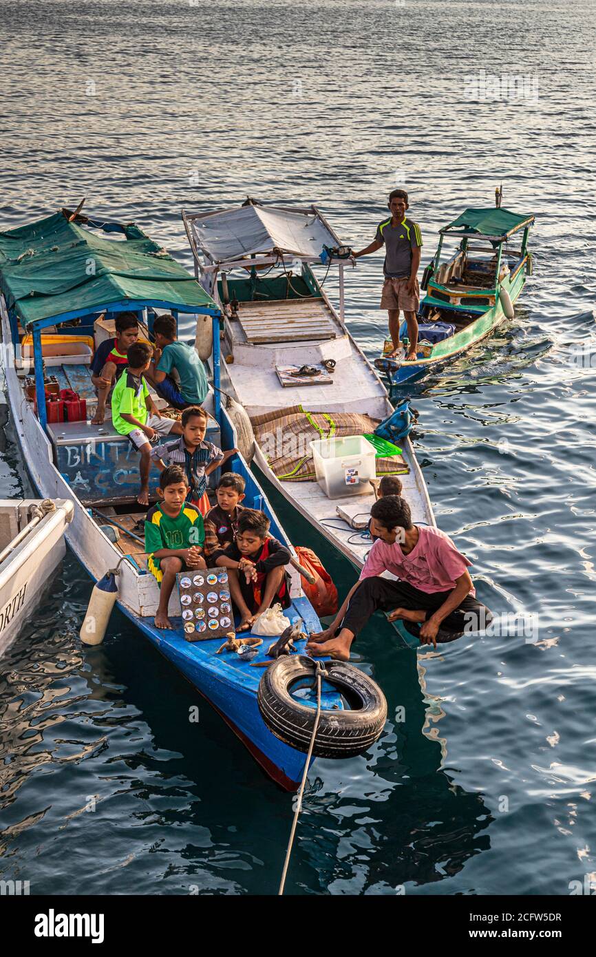 Les habitants de la région offrent des produits locaux du bateau à la croisière de tir et de dragons du Nord vrai, aux îles Sunda, en Indonésie Banque D'Images