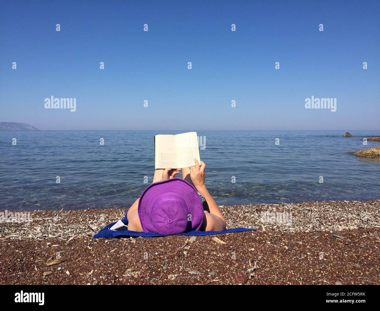 Lecture sur la plage. Détente avec un bon livre au bord de la mer. Banque D'Images