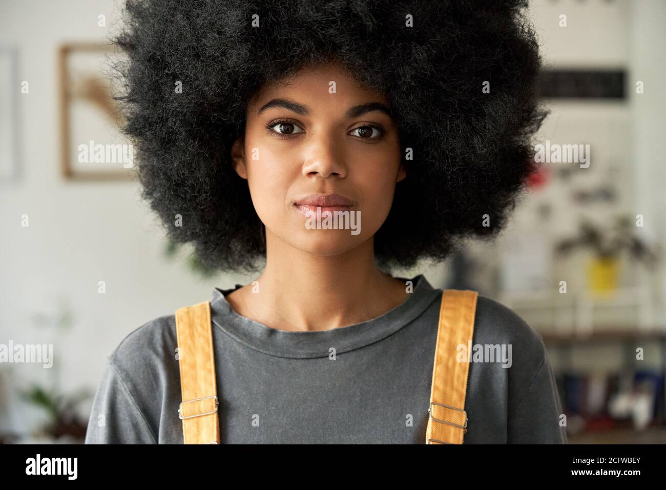 Femme africaine confiante avec cheveux afro regarde l'appareil photo, portrait de tête. Banque D'Images