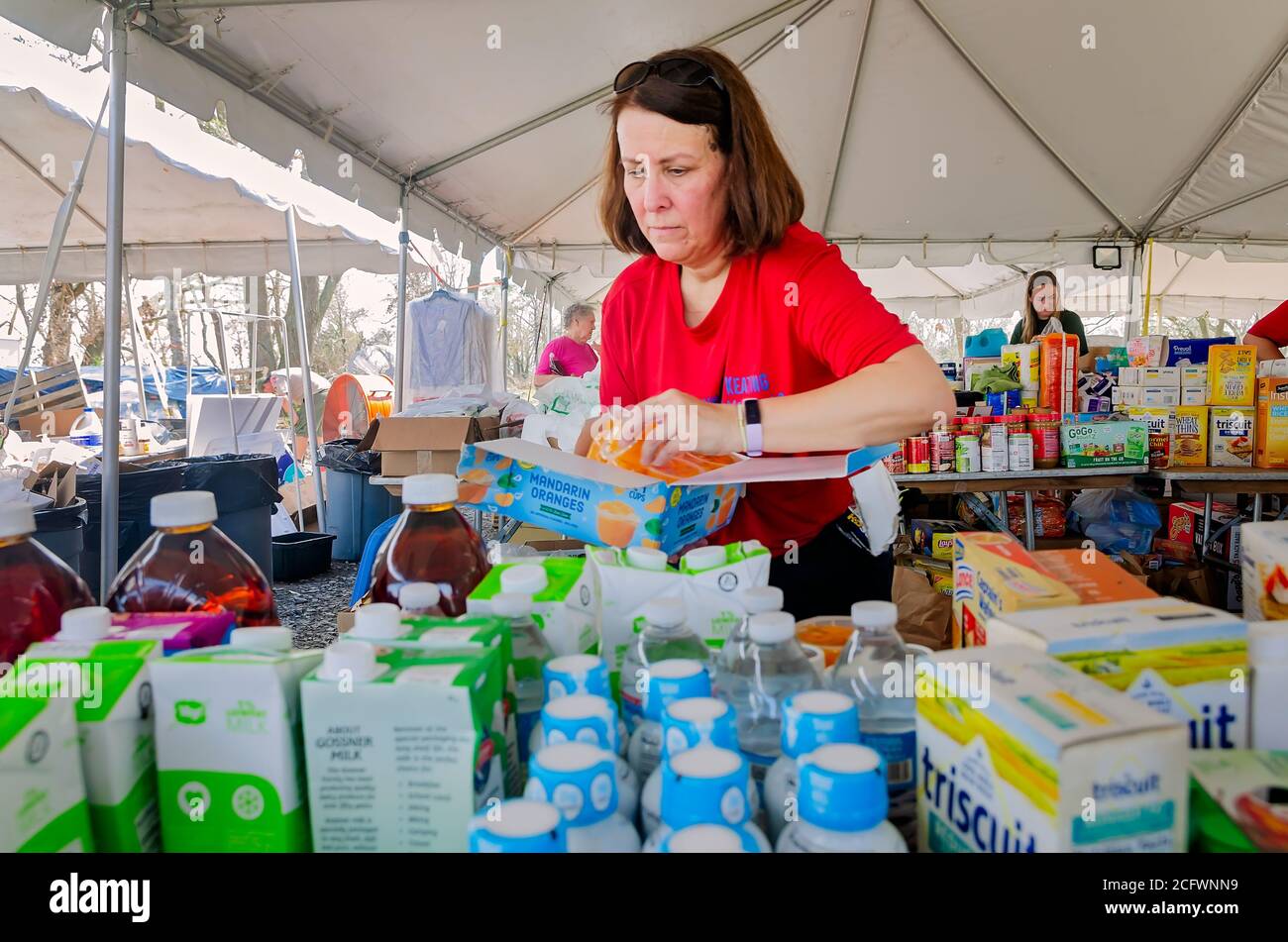 La bénévole Judy Ehrhart place des mandarines oranges sur une table avec d'autres dons pour les victimes de l'ouragan Laura, le 6 septembre 2020, à Bell City, en Louisiane. Banque D'Images