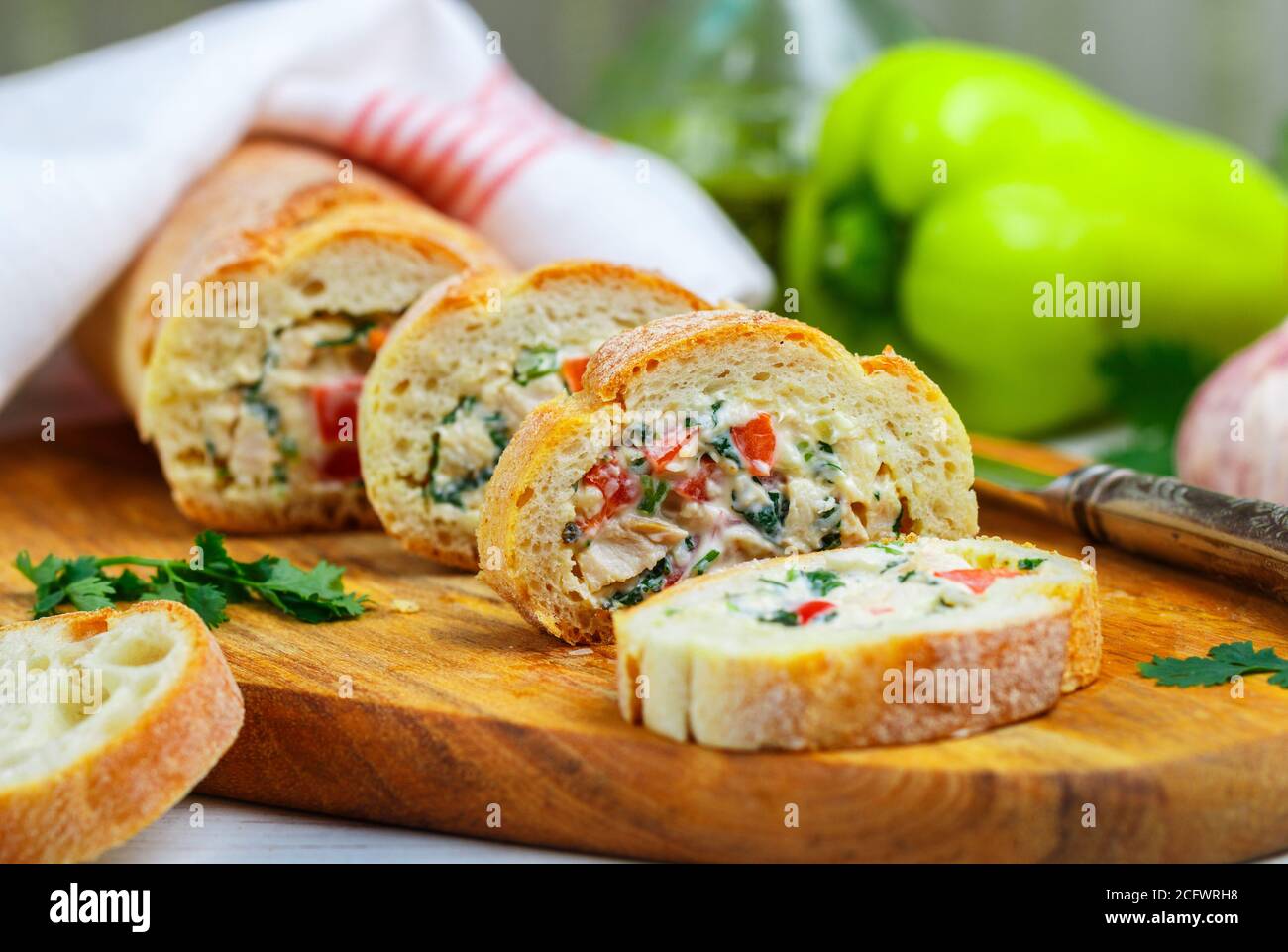 Baguette farcie avec une salade de poulet cuit, fromage et légumes frais - poivron, tomate, ail, persil. Délicieux hors-d'œuvre maison pour gou Banque D'Images