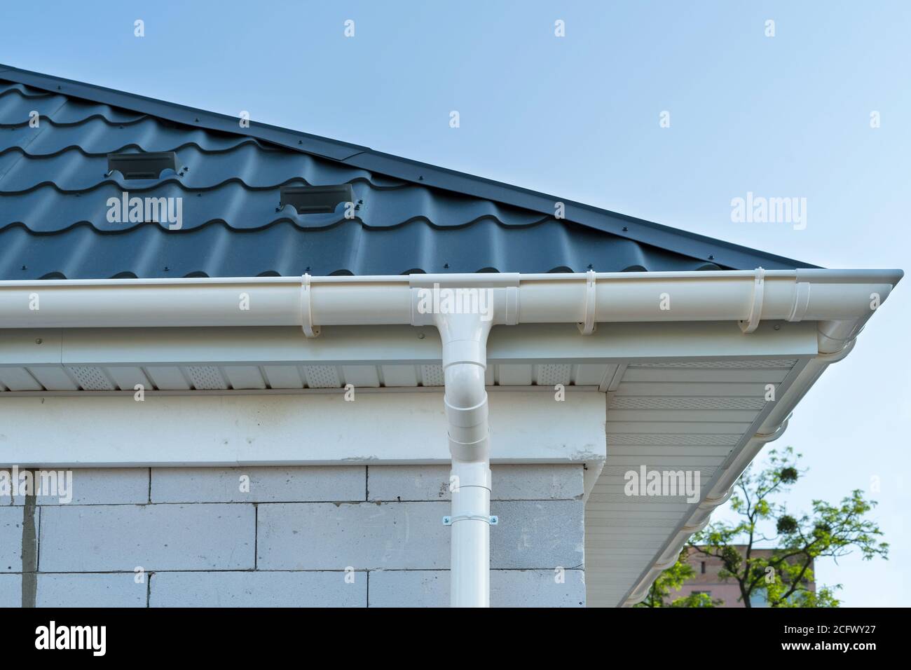 Nouveau toit en carreaux de métal avec gouttière blanche. Construction de panneaux SIP. Bâtiment non fini. Banque D'Images
