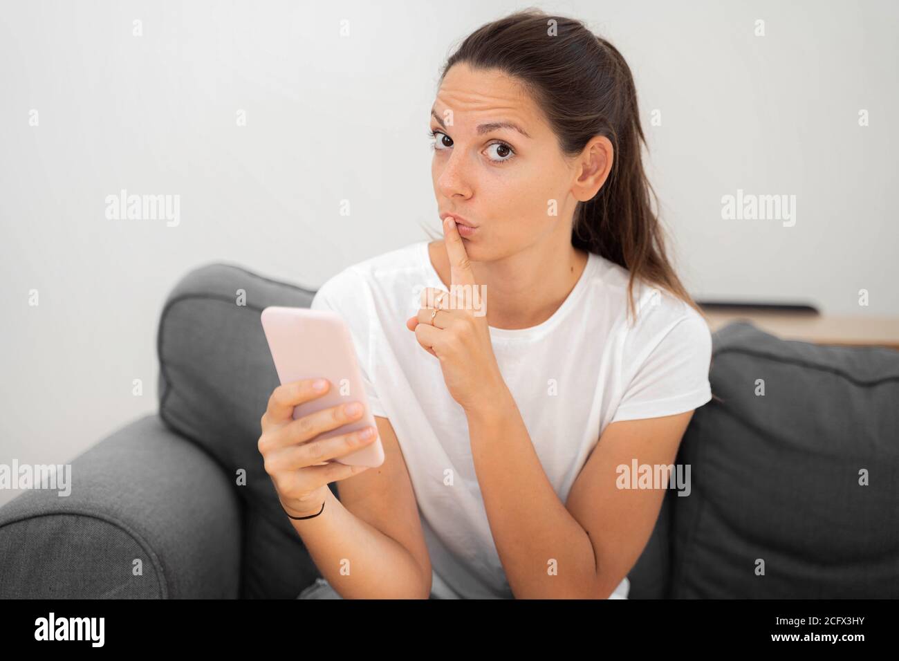 Jeune femme caucasienne avec téléphone. Censure sur Internet. Banque D'Images