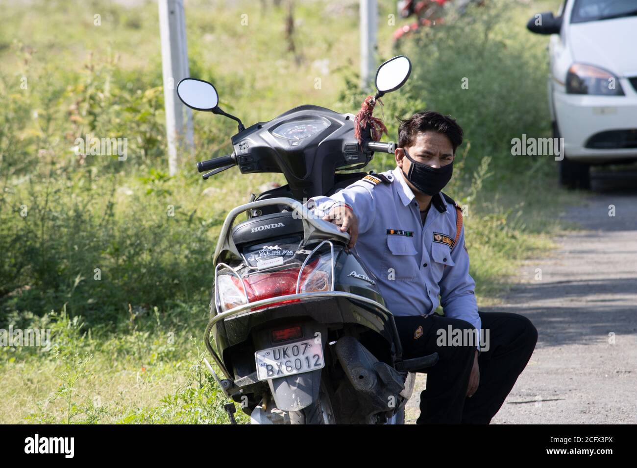 Dehradun, Uttarakhand/India - septembre 06 2020:UN homme de sécurité assis sur son scooter, portant un masque facial. Banque D'Images