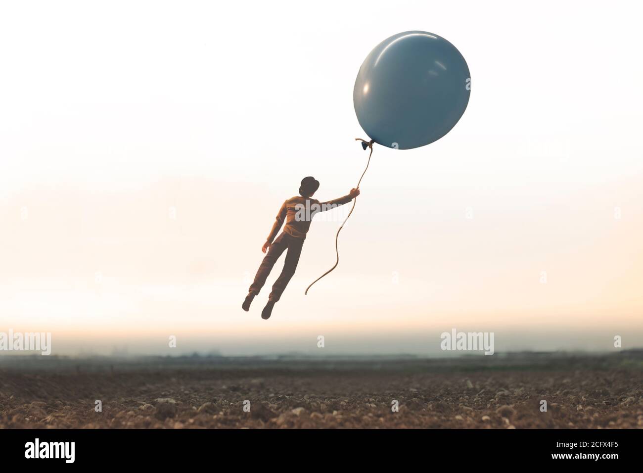 un moment surréaliste, un homme volant librement avec un grand ballon Banque D'Images