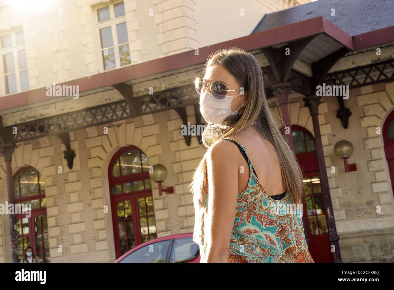 Jeune voyageur femme marchant à la gare avec le visage masque Banque D'Images