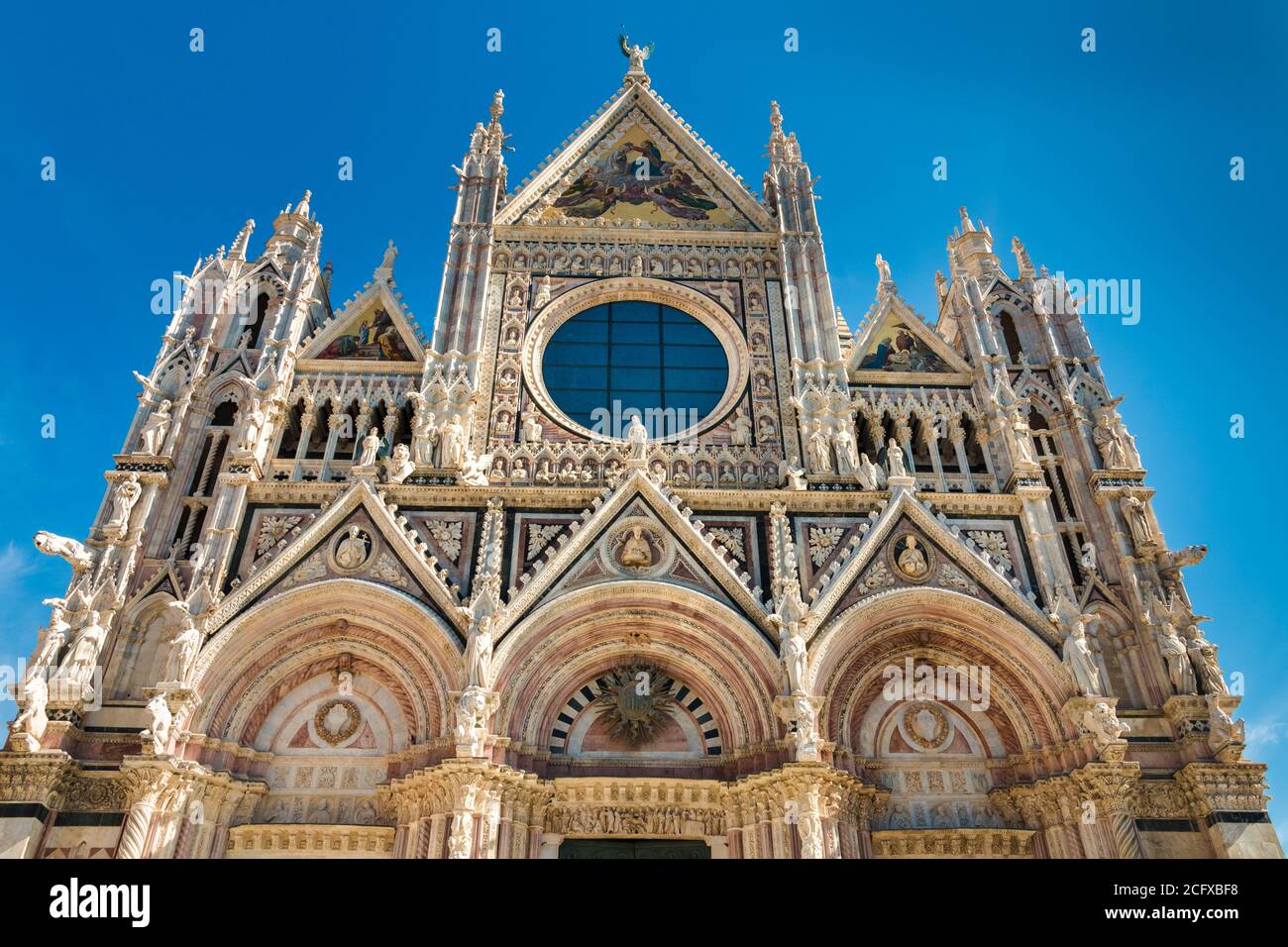 Photo parfaite en gros plan à bas angle de la façade ouest du célèbre Duomo di Siena, une cathédrale médiévale de Sienne, en Italie. Construit en marbre polychrome,... Banque D'Images