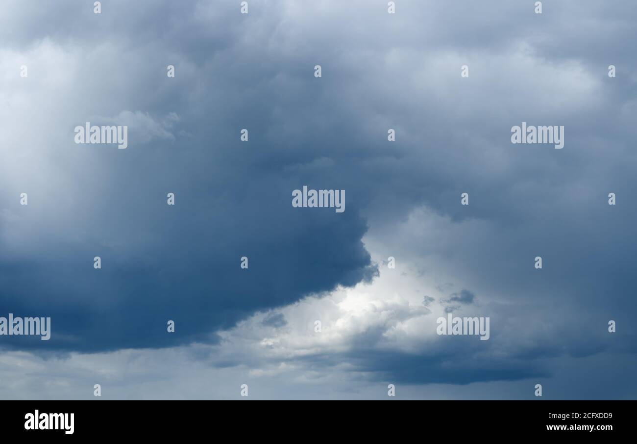 Majestueux nuages de faible pluie avec lumière du soleil sur l'horizon. Ciel orageux... Banque D'Images